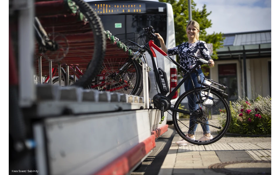 Mädchen läd ihr Rad auf den Anhänger am Fahrrradbus auf.