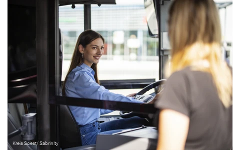 Busfahrerin lässt Personen in den Bus einsteigen
